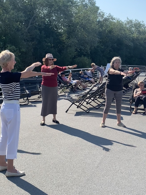 Group of women exercising on a boat deck.