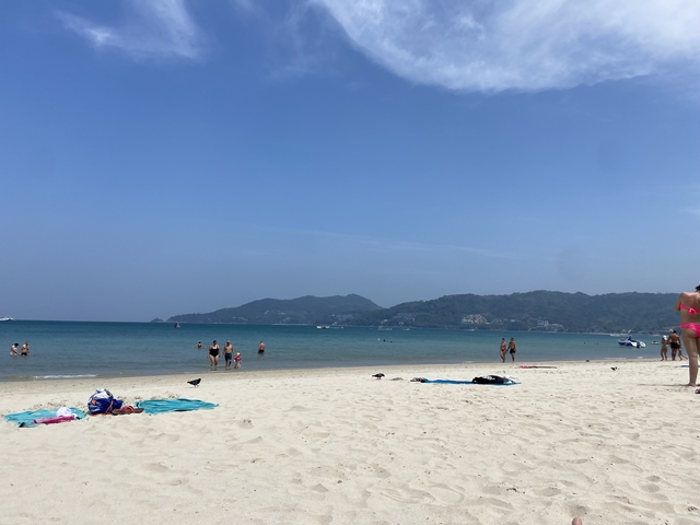 Beach scene with people and clear waters.