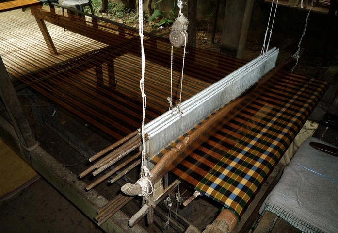 Traditional weaving loom with patterned fabric.