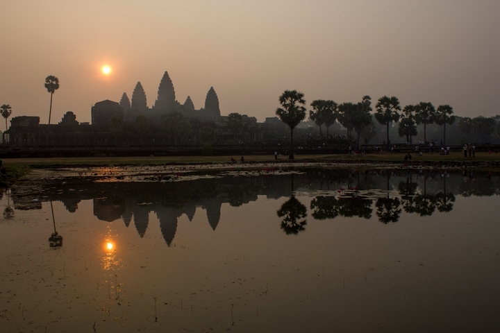 Angkor Wat silhouette at sunrise with reflections.