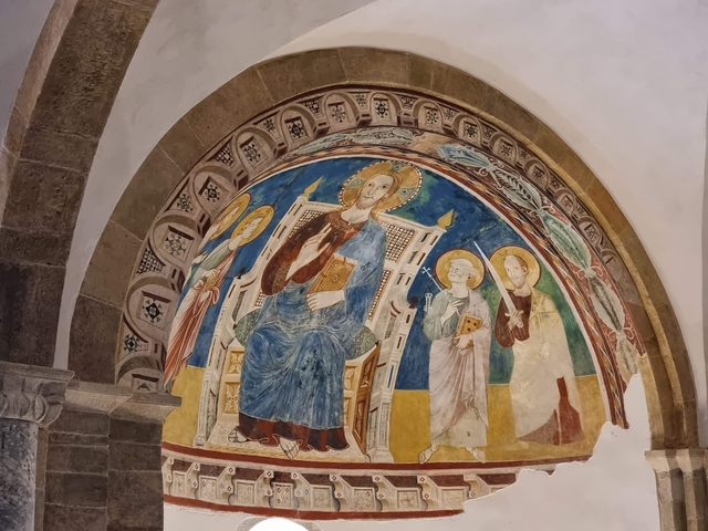 Religious fresco with saints painted inside an arch.