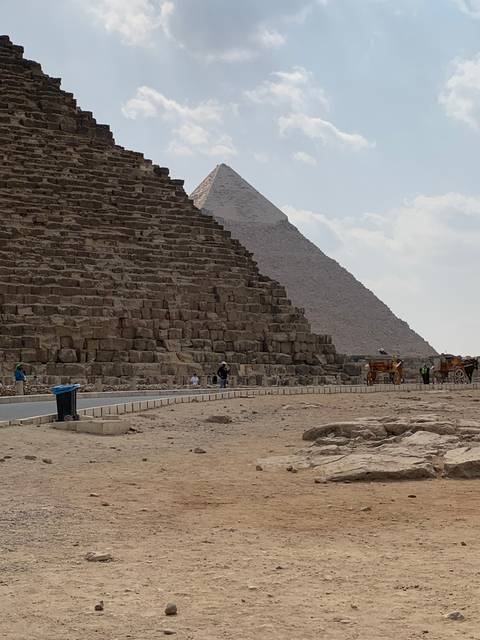 The Great Pyramid partially visible against the desert sky.