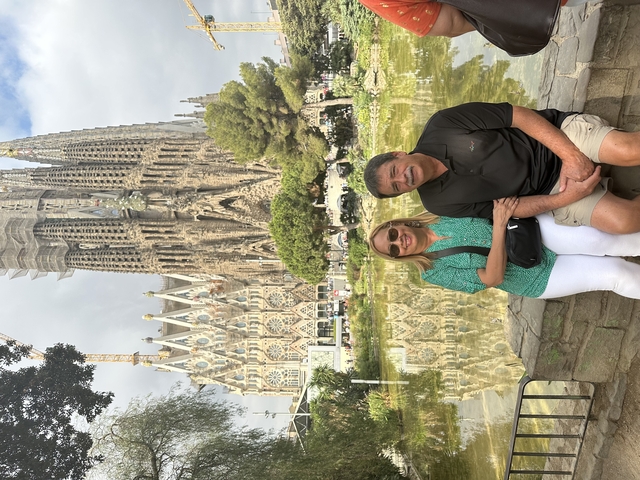 A couple sitting by a park with a famous basilica in the background.