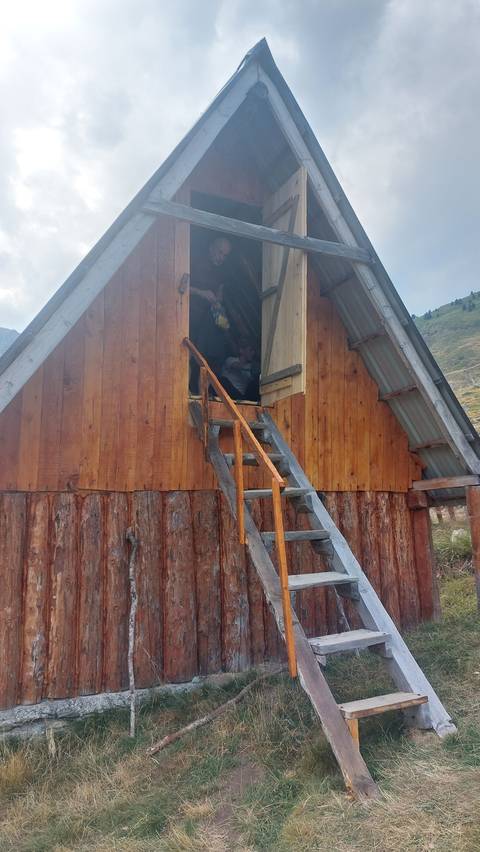 Wooden cabin with a ladder leading to the entrance.