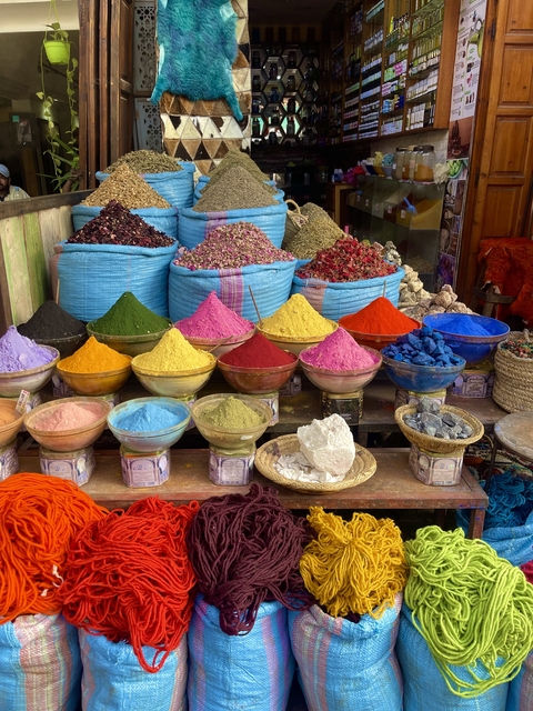 Colorful spice powders displayed in bowls in a market.