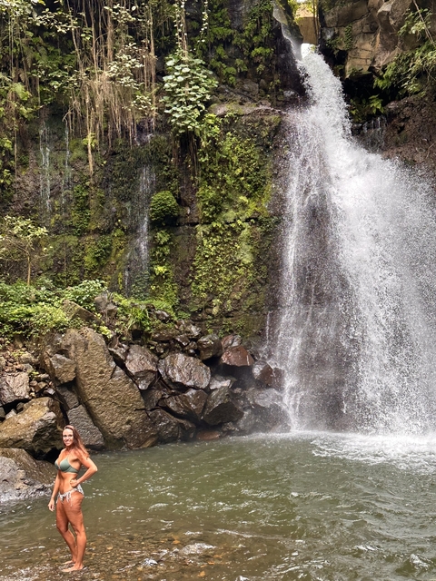 Waterfall cascading over rocks with lush greenery.