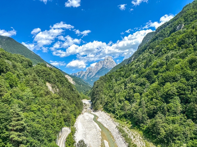A scenic view of a river canyon flanked by forested mountains.