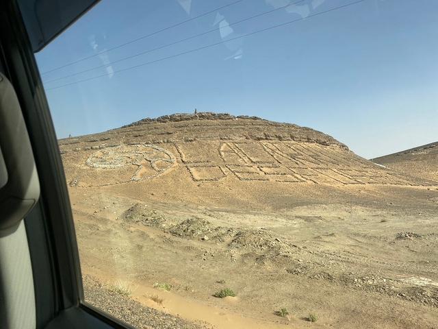 Desert hillside with stones arranged in a pattern.