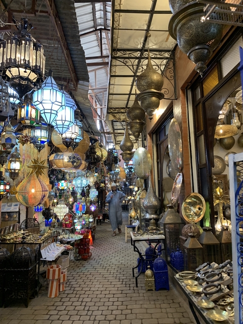 Decorative metal lamps in a vibrant street market.