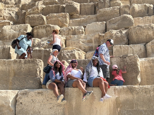 People sitting on the steps of a pyramid.