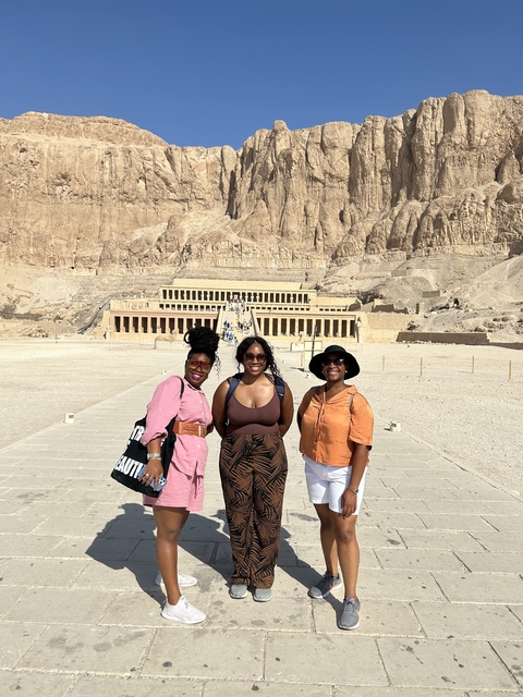 Three people posing in front of an ancient temple.