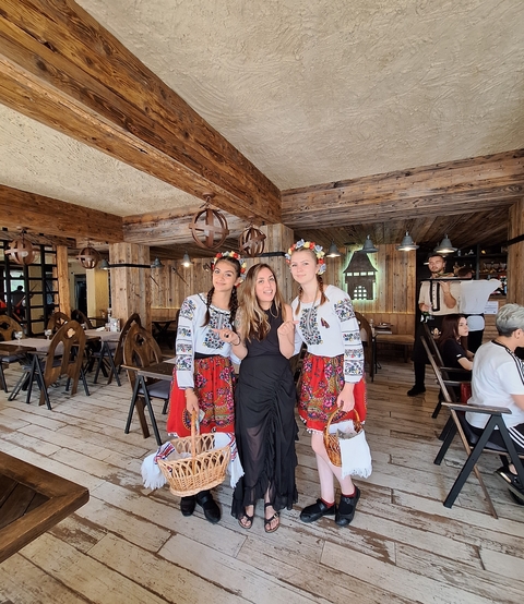 Group of people in traditional dress inside a rustic restaurant.