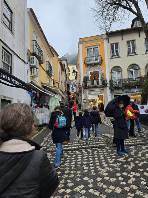 Busy street scene with people and colorful buildings.