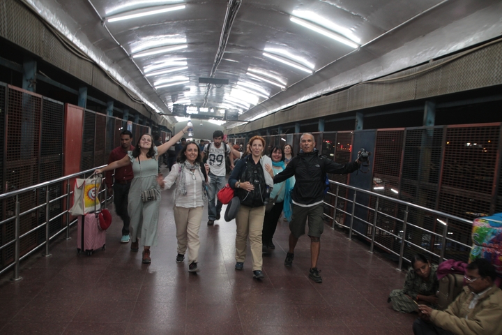Group of people joyfully walking on a footbridge at night.