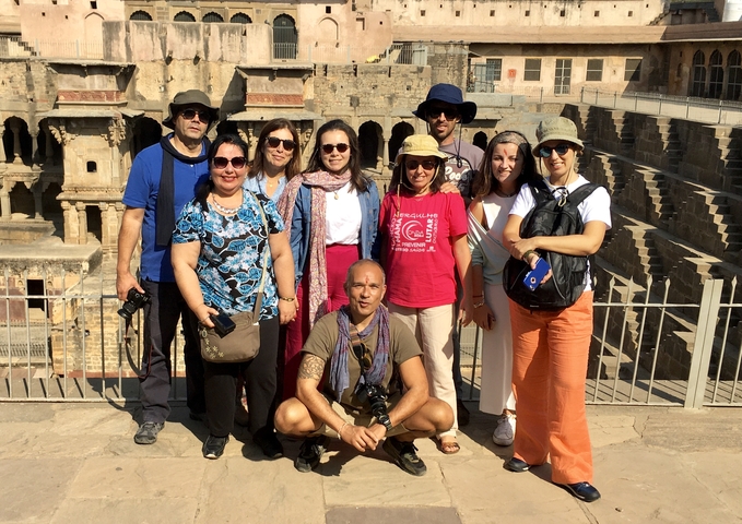 Group of people with a stepwell in the background.