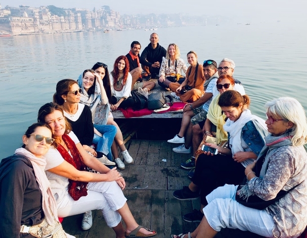 Group of people sitting in a boat on a calm lake.
