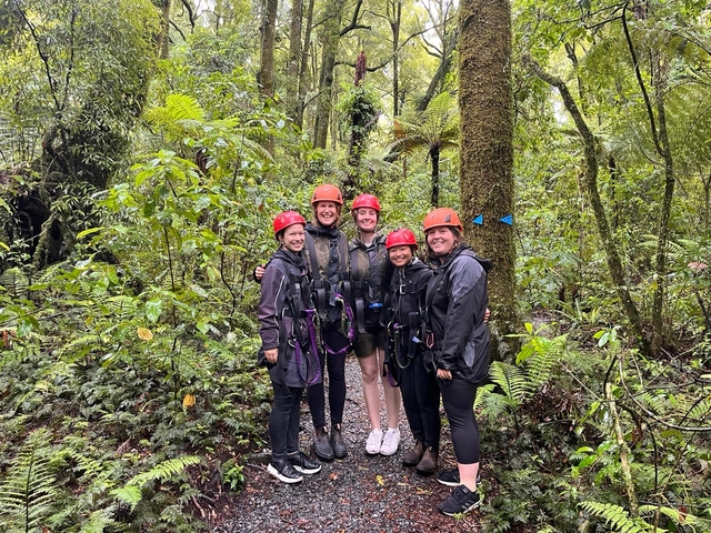 Group of five ready for zip lining in a forest.