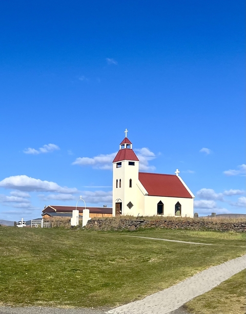 A red-roofed church against a clear blue sky.