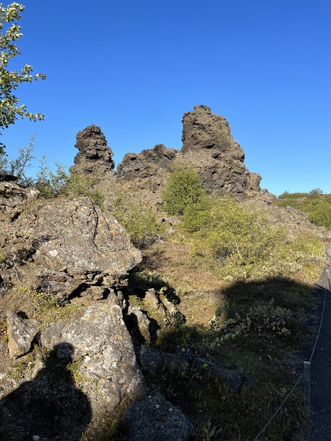 Rugged volcanic terrain with vegetation.