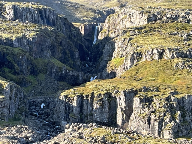 Waterfall flowing through a rocky gorge.