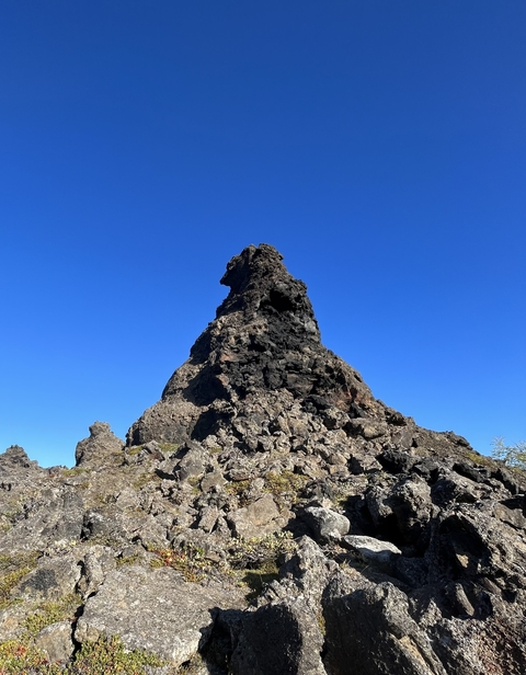 Rugged rocky formation under a clear blue sky.