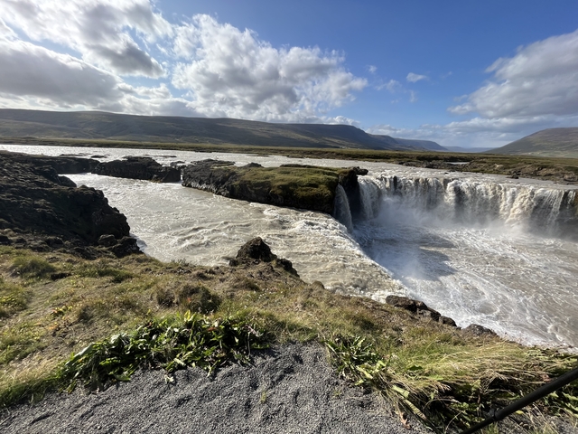 Powerful waterfall with surrounding rocky landscape.