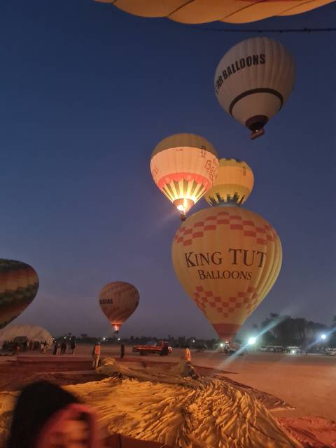 Hot air balloons being inflated at dusk.