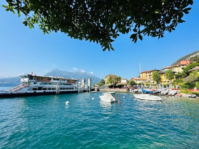 Small marina with boats, pier, and mountainous backdrop.