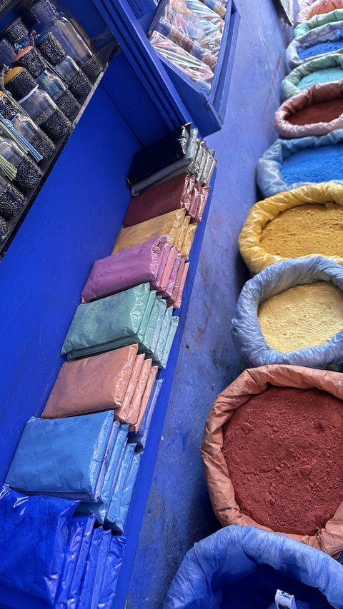 Colorful powder packets and bowls displayed in a market.