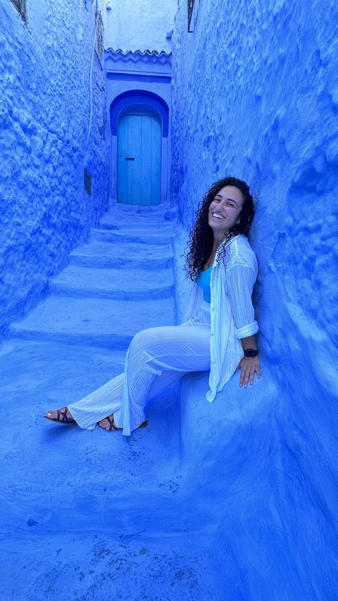 Woman sitting on blue-painted steps.