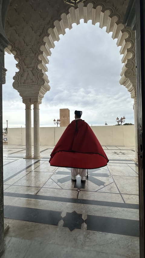 Person in traditional attire standing in an archway.