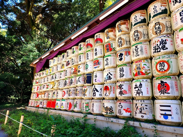 Rows of Japanese sake barrels stacked in a forest.