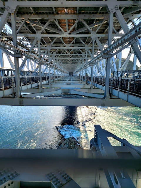 Bridge structure with view of water below.
