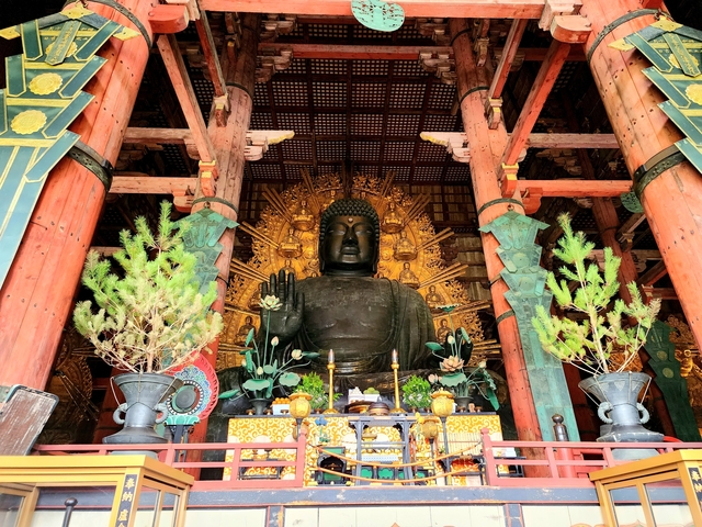 Large Buddha statue inside a temple with decorations.
