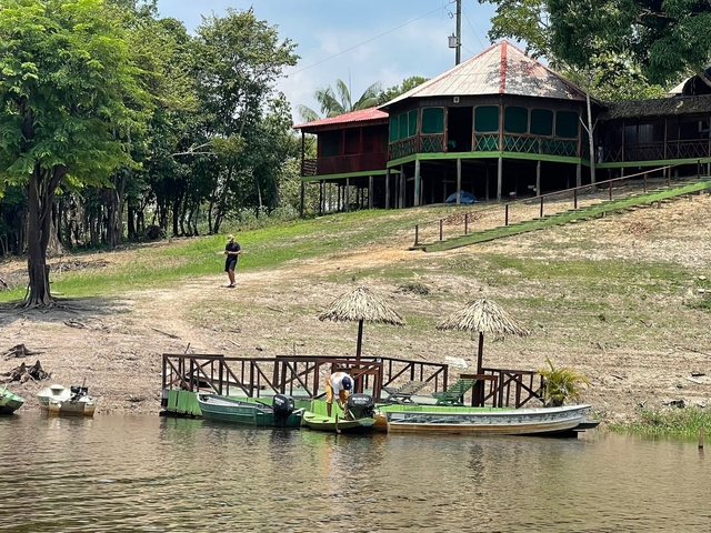 House with boats and people near a river.