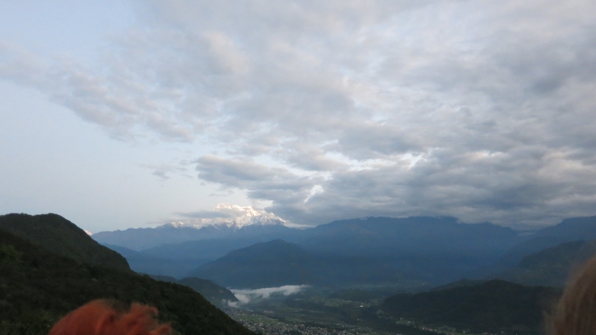 Mountain range under a cloud-filled sky with a valley below.