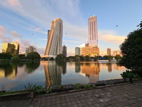 Cityscape reflection in a tranquil lake with modern skyscrapers.