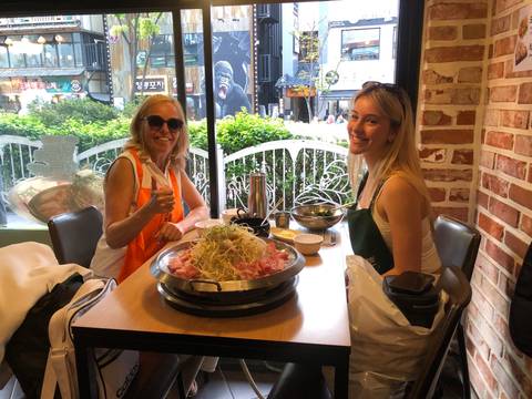 Upside-down image of two women at a table with food dishes.
