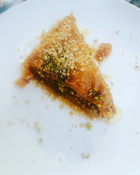 Baklava dessert with nuts on a white plate.
