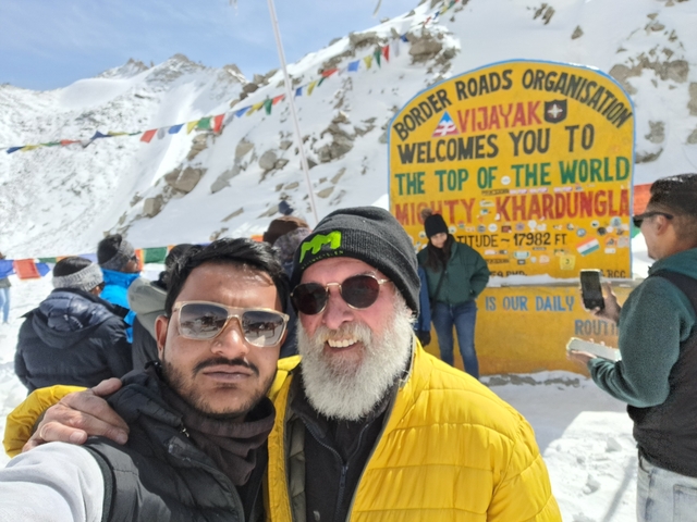 Group at an elevation marker in a snowy area.