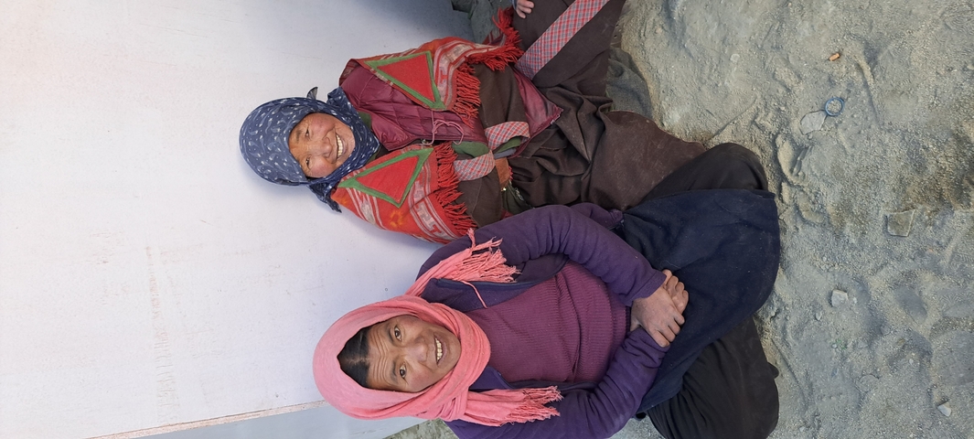 Two people sitting and smiling at the camera.