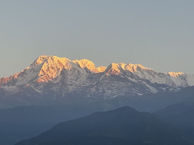 Snow-covered mountains with sunlight glowing on the peaks.