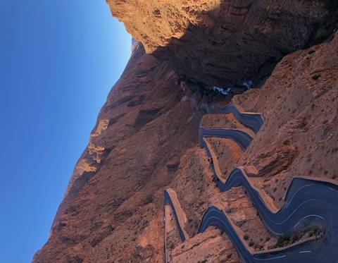 Curvy mountain road surrounded by rocky formations.