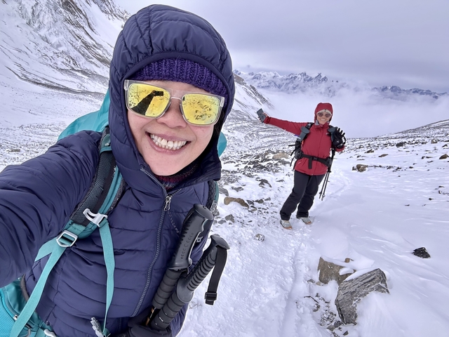 Two people posing on a snowy mountain.