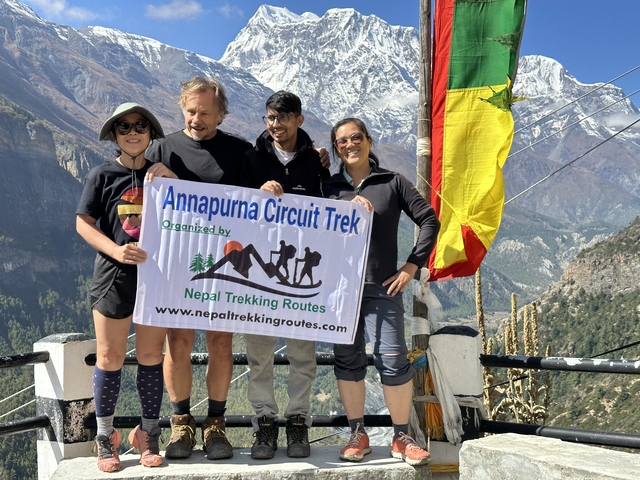 Group holding a banner with mountains in background.