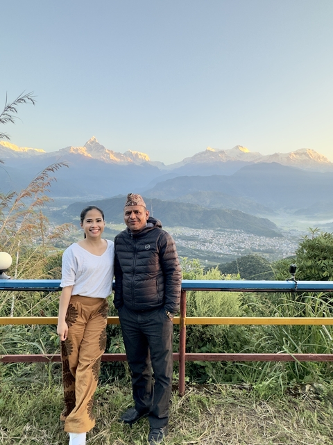 Two people posing with a scenic mountain view.