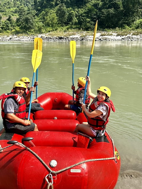 Group rafting on a river with yellow helmets.