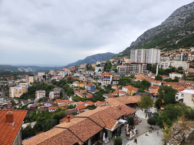 Cityscape with mountainous terrain in the background.