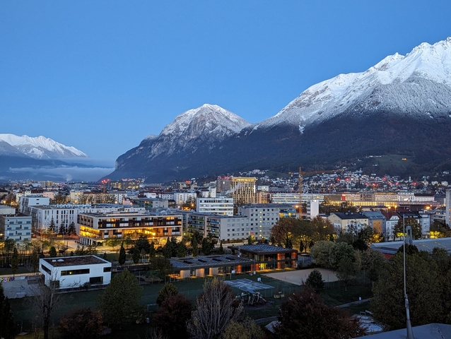 City with buildings and bright mountains in the background.