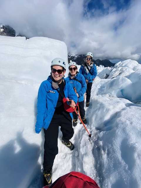 Group of people on a glacier hike wearing helmets and gear.
